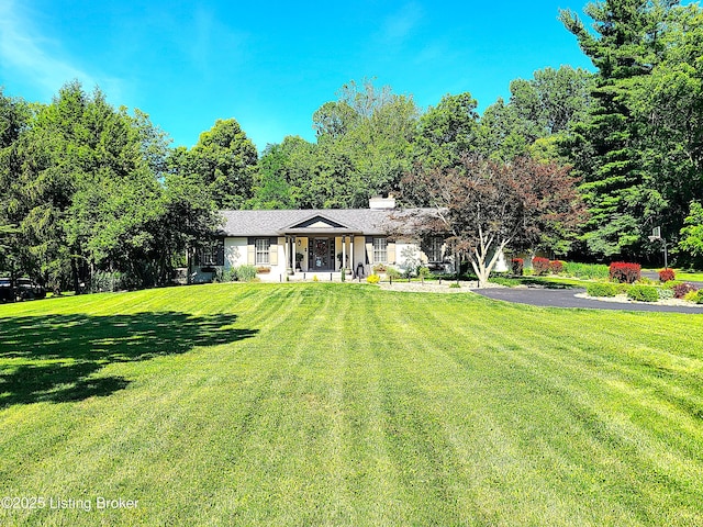 view of front of house with a chimney and a front yard