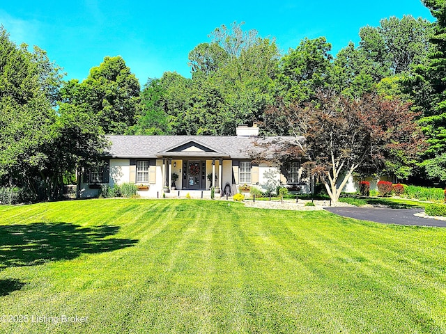 view of front facade featuring a front yard and a chimney