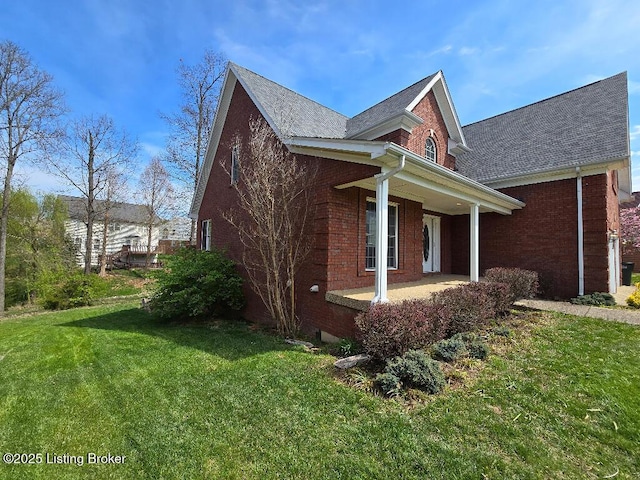 view of home's exterior with brick siding, a lawn, and a patio