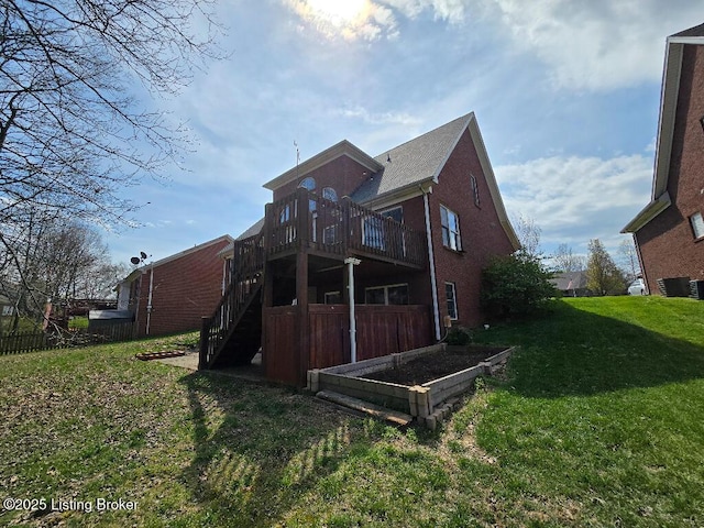 back of house with central AC, brick siding, a lawn, and stairway