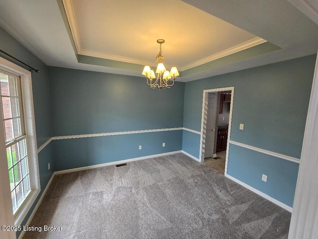 spare room with a tray ceiling, carpet, baseboards, and an inviting chandelier