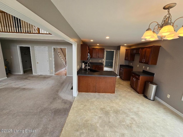 kitchen with recessed lighting, a peninsula, a sink, baseboards, and dark countertops