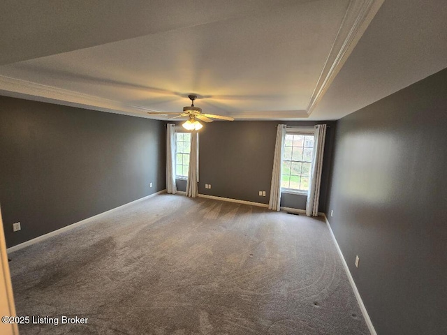 carpeted empty room with crown molding, a ceiling fan, a wealth of natural light, and baseboards