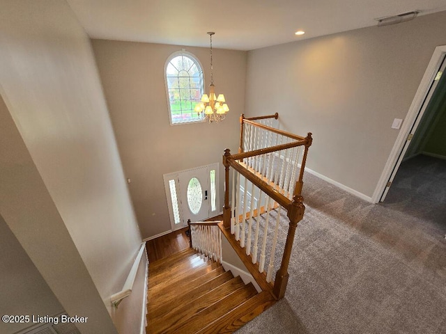 stairs with carpet, baseboards, a notable chandelier, and recessed lighting