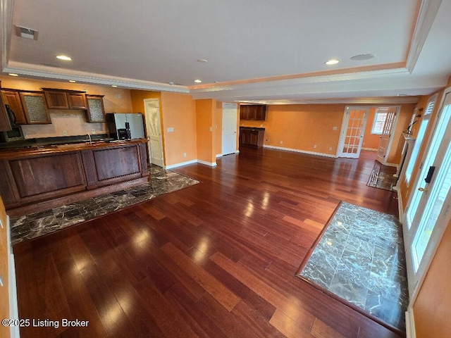 kitchen with dark countertops, a raised ceiling, visible vents, and open floor plan