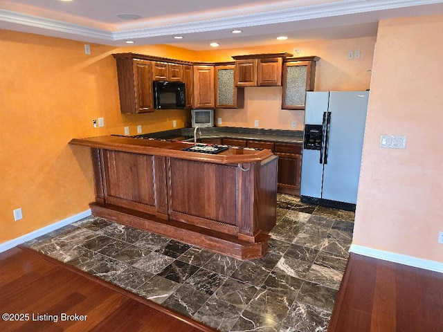 kitchen with baseboards, dark countertops, a peninsula, fridge with ice dispenser, and black microwave