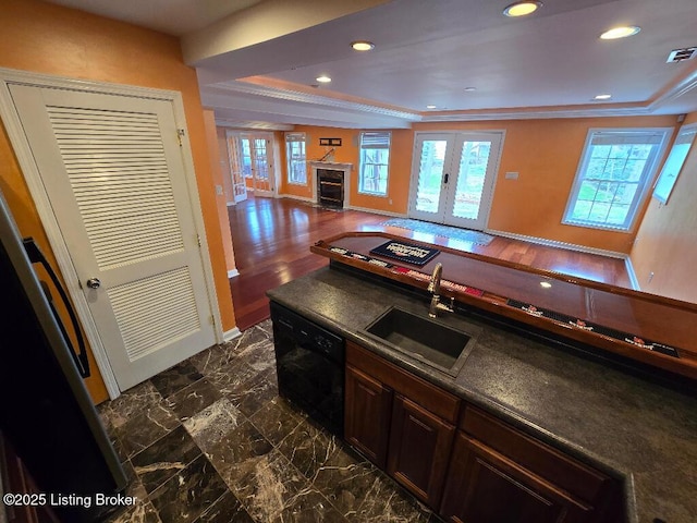 kitchen featuring french doors, dark countertops, a fireplace with flush hearth, a sink, and dishwasher