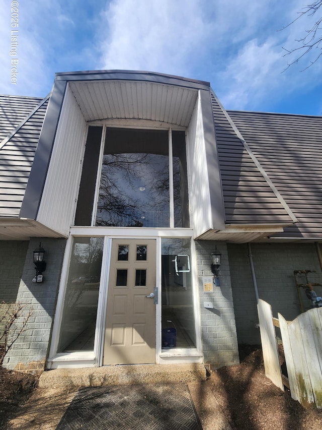 view of exterior entry with brick siding