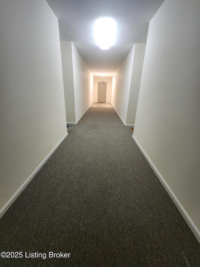 corridor with baseboards and carpet floors