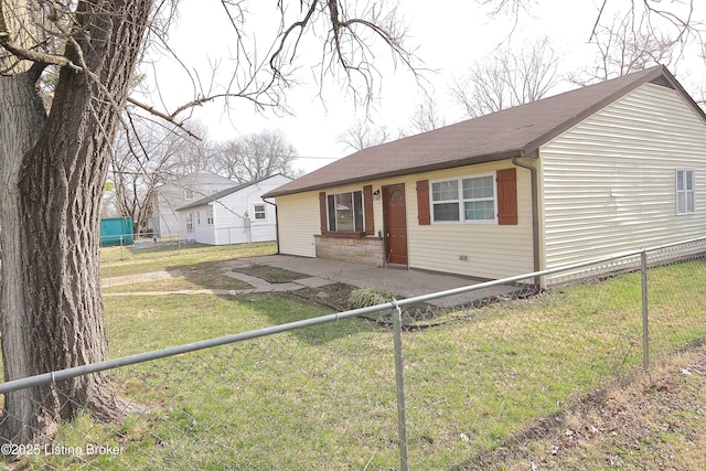 view of front facade with fence private yard, a front lawn, and a patio area