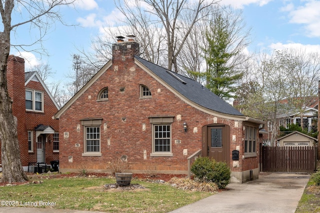 view of side of property featuring roof with shingles, a chimney, a lawn, and brick siding