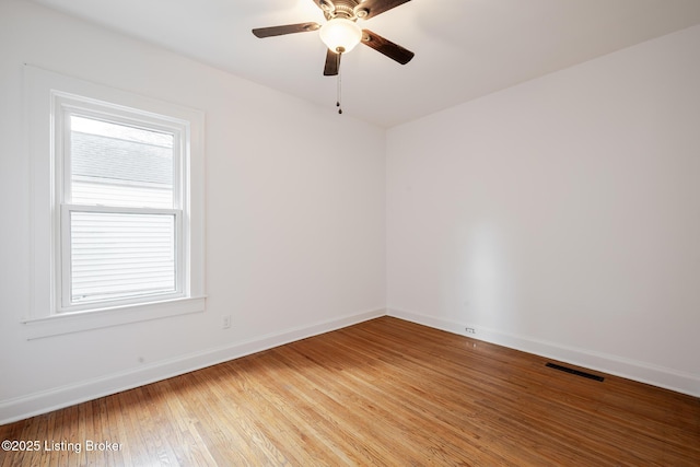 unfurnished room featuring light wood-style floors, baseboards, visible vents, and ceiling fan