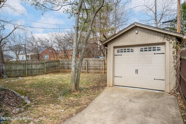 view of yard with an outbuilding, fence, driveway, and a detached garage