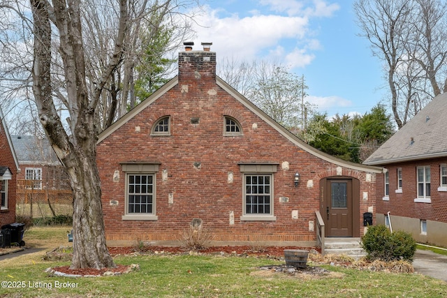 view of front facade featuring a chimney and brick siding