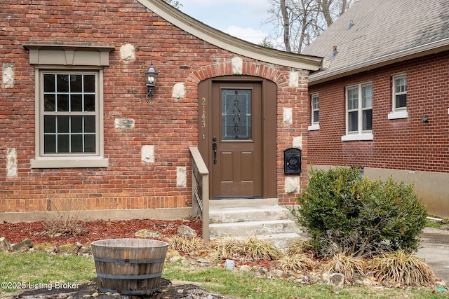 view of exterior entry featuring brick siding