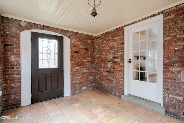 interior space with light tile patterned floors and brick wall