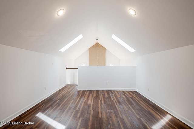 additional living space featuring a skylight, baseboards, and dark wood finished floors