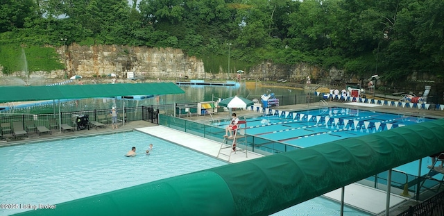 community pool featuring fence and a patio