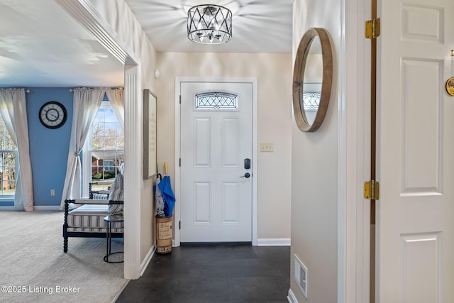 entryway featuring visible vents, dark carpet, and baseboards