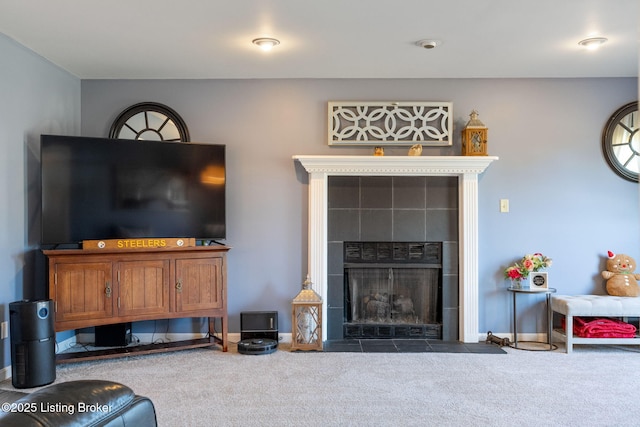 carpeted living area featuring a fireplace and baseboards