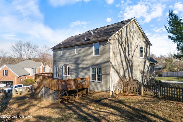 back of house featuring a lawn, a wooden deck, and fence