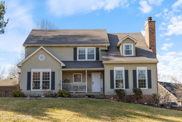 view of front of house with a porch, a front yard, and a chimney