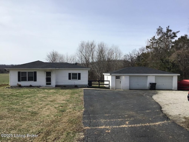 single story home featuring a garage, a front lawn, and an outdoor structure