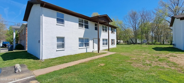 view of home's exterior with brick siding and a yard