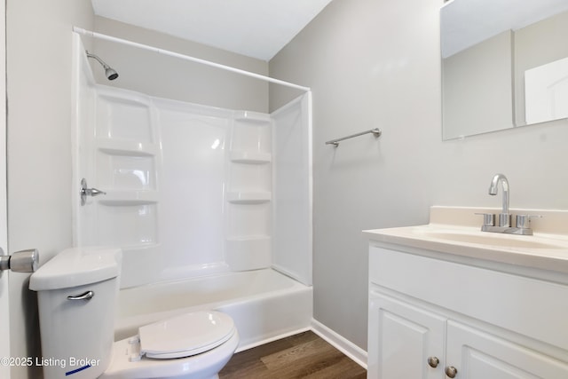 full bathroom with bathing tub / shower combination, vanity, toilet, and wood finished floors