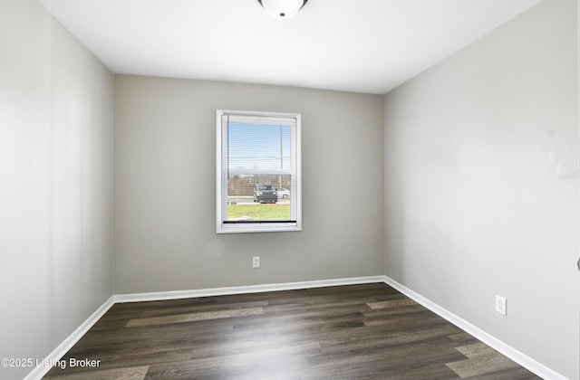 unfurnished room with dark wood-style floors and baseboards