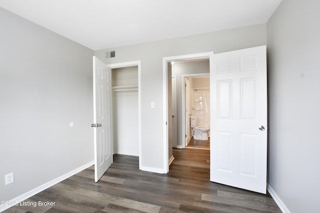 unfurnished bedroom with a closet, visible vents, dark wood finished floors, and baseboards