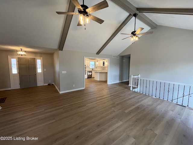 unfurnished living room featuring visible vents, baseboards, wood finished floors, and beamed ceiling