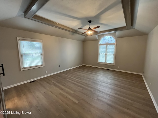 unfurnished room featuring visible vents, baseboards, a ceiling fan, dark wood-style flooring, and vaulted ceiling