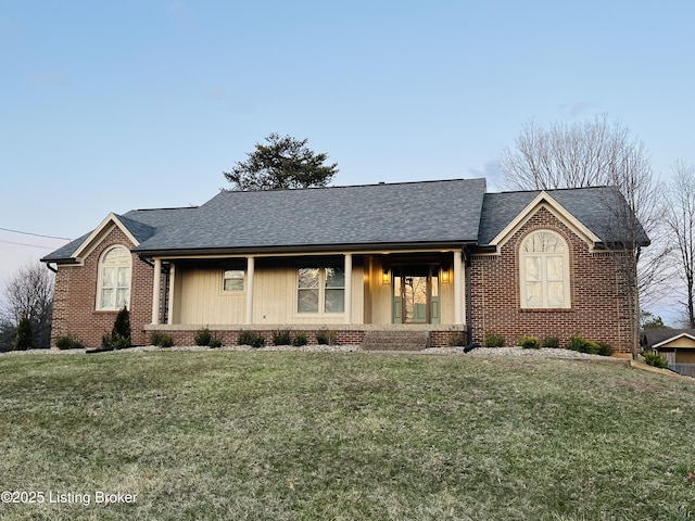 ranch-style house with brick siding, roof with shingles, and a front yard