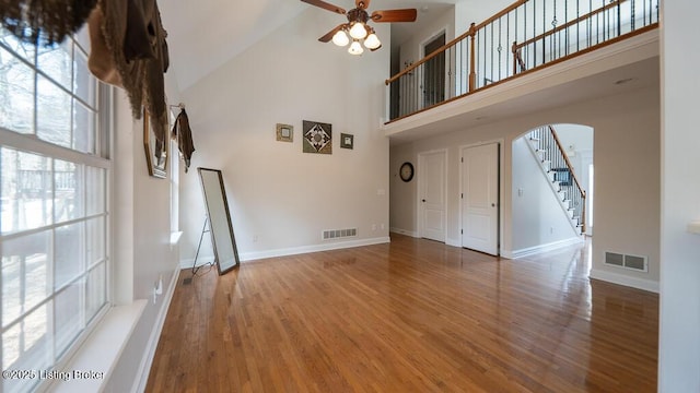 unfurnished living room with baseboards, wood finished floors, visible vents, and a ceiling fan