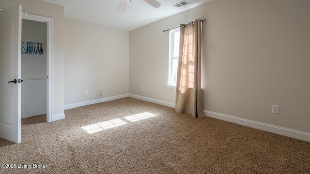 unfurnished bedroom featuring carpet floors, baseboards, visible vents, and a ceiling fan