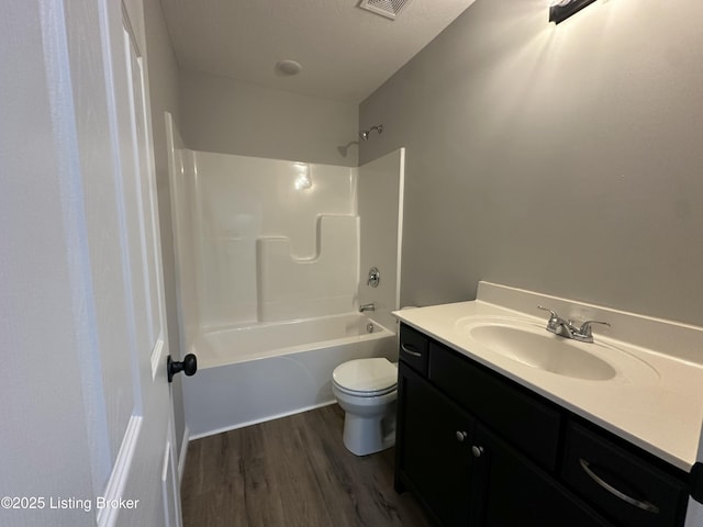 bathroom featuring toilet, vanity, bathing tub / shower combination, and wood finished floors