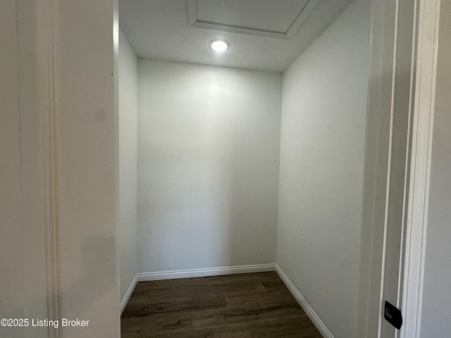 interior space with baseboards, attic access, and dark wood-style floors