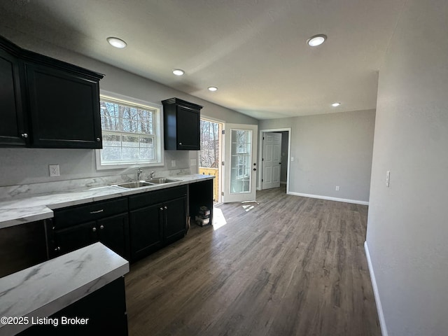 kitchen featuring a sink, baseboards, recessed lighting, wood finished floors, and dark cabinets