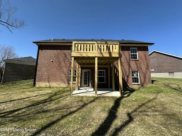 back of house with a yard, a patio area, brick siding, and a wooden deck