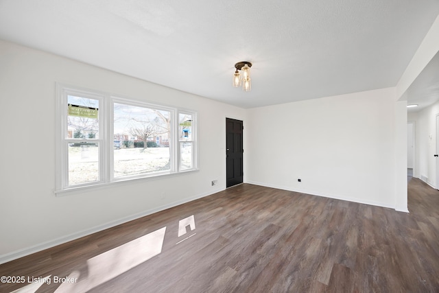 empty room with wood finished floors and baseboards