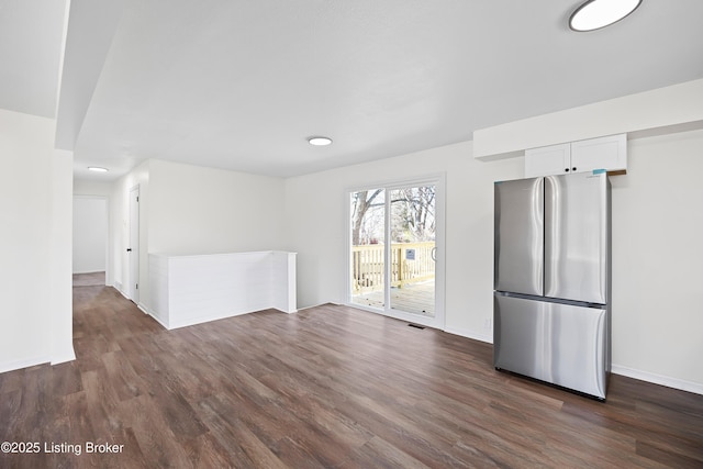 interior space featuring dark wood-type flooring, visible vents, and baseboards