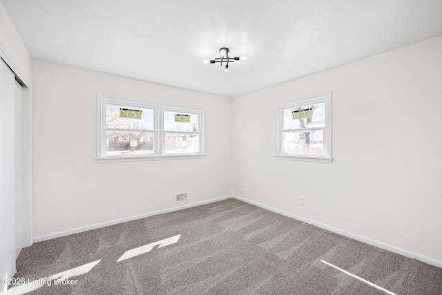 unfurnished bedroom with carpet floors, a closet, visible vents, and baseboards