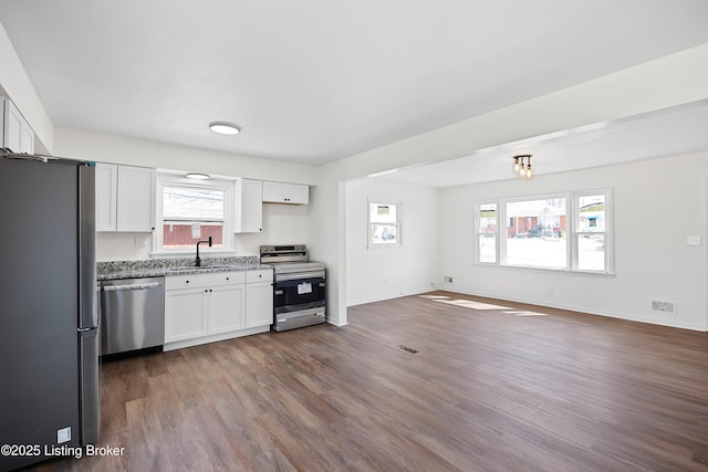 kitchen featuring dark wood-style floors, white cabinetry, appliances with stainless steel finishes, and a sink