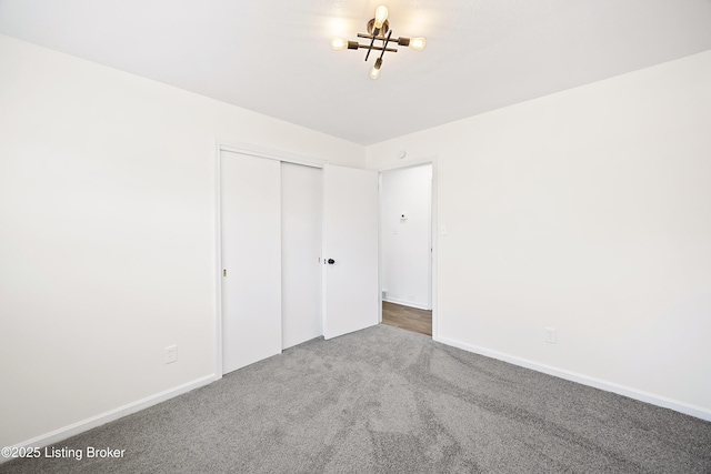 unfurnished bedroom with carpet floors, a closet, and baseboards