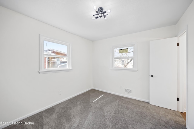 empty room featuring baseboards, carpet flooring, visible vents, and a healthy amount of sunlight