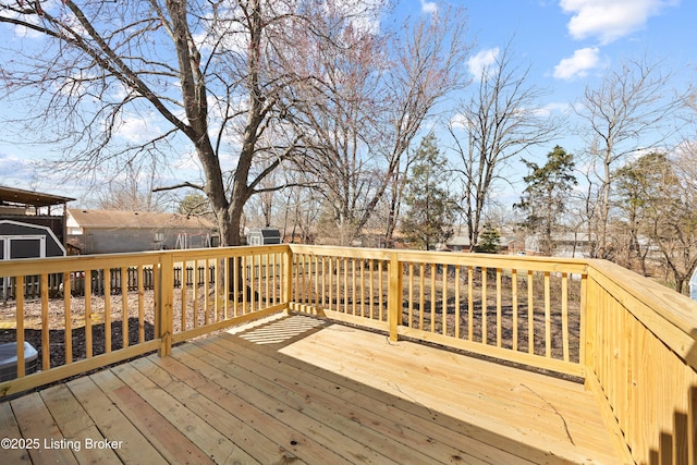 wooden deck with an outbuilding and a storage shed