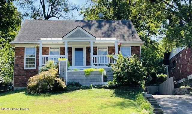 view of front of home with brick siding, stairway, and a front yard