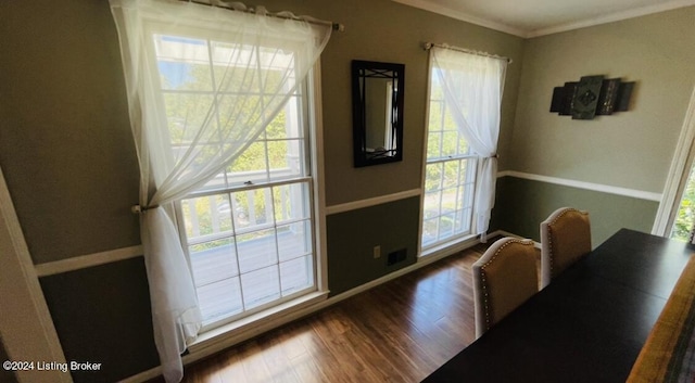 dining area featuring a healthy amount of sunlight, baseboards, ornamental molding, and wood finished floors