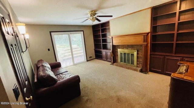 living room featuring a brick fireplace, built in features, a ceiling fan, and light colored carpet